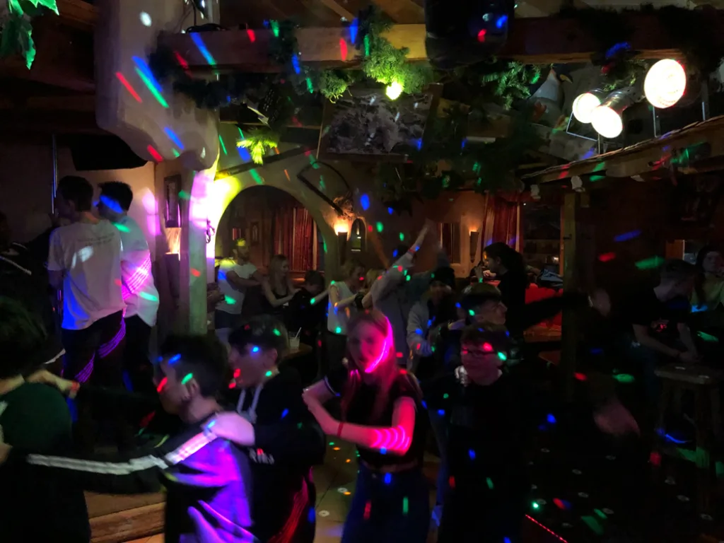 Tanzende unter bunten Lichtern in der Hütte.